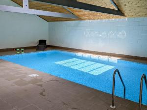 a large swimming pool with blue water in a room at Camelia Cottage-uk37205 in Sancreed