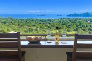 a table with two glasses and a bottle of wine at Casa Hola in Coco