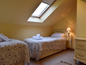 2 Betten in einem Schlafzimmer im Dachgeschoss mit Dachfenster in der Unterkunft Mange-tout Maison - Uk32607 in Manton