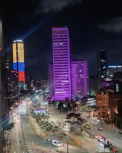 een skyline van de stad 's nachts met paarse lichten bij Wohnung Queens Deluxe in Bogota