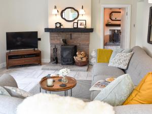 a living room with a couch and a fireplace at Finkle Cottage in Pooley Bridge
