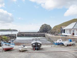 a group of boats are parked on the beach at Honeysuckle Cottage in Cury