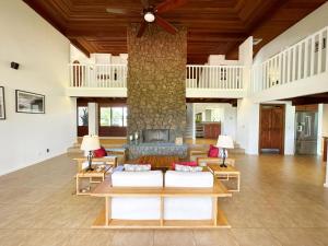 een woonkamer met een grote stenen pilaar bij Coral Hale 5br 3ba Luxury Home, AC, Hot Tub and Stunning Views in Princeville