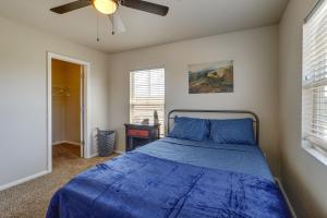 een slaapkamer met een blauw bed en een plafondventilator bij Pristine Parker Retreat with Patio and 2 Fireplaces! in Parker