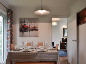 Totland的住宿－Sea Breezes，用餐室配有桌椅和绘画作品