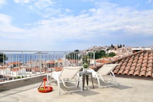 een patio met een tafel en stoelen op een dak bij Design Architectonika in Skiathos-stad