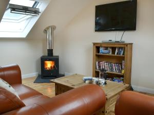 a living room with a couch and a fireplace at Stonechat Barn in Pancrasweek