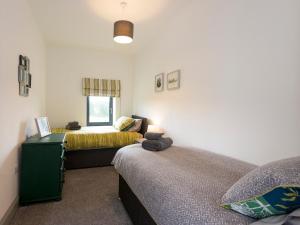 a bedroom with two beds and a window at Moorgate Cottage in Kelbrook