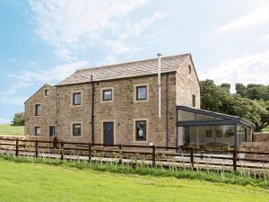 a large brick house with a glass extension at Moorgate Cottage in Kelbrook
