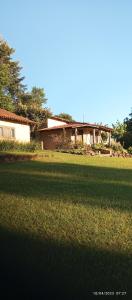 a house sitting in the middle of a field of grass at Pousada Longe Vista in Tibagi
