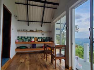 a kitchen with a table and a large window at Flow Nature Cottage in Beragala