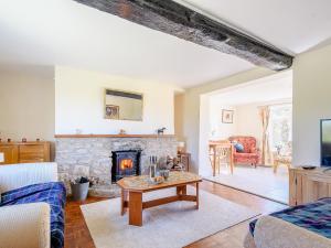 a living room with a fireplace and a couch at Rathlin Cottage in Cambridge