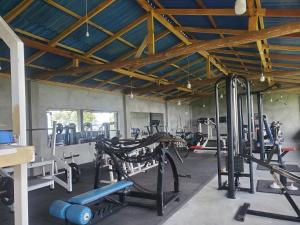 a gym with several tread machines in a room at Flow Nature Cottage in Beragala