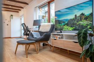 a living room with a large tv on a wall at New Cozy Central Scandinavian Skylight House in Horsens