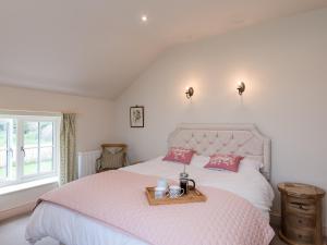 a bedroom with a bed with a tray on it at White Lodge Cottage in Carlton Miniott