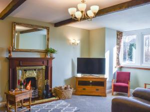 a living room with a fireplace and a television at White Abbey in Kildwick