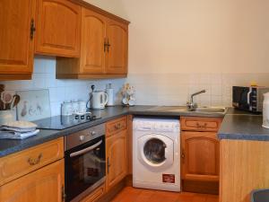 a kitchen with a washing machine and a sink at Badger in Gunnislake
