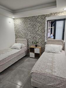 a bedroom with two beds and a small table at laila's boutique apartment in Haifa