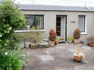 a house with potted plants in front of it at Keith House in Thurso