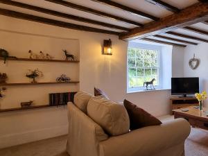sala de estar con sofá y ventana en Karslake Cottage en Winsford