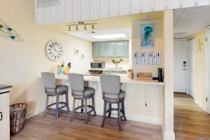 a kitchen with a counter and stools in a room at Sand Dollar W202 in Pensacola Beach