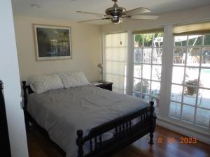 a bedroom with a bed and a ceiling fan at Nice Northridge 4-2-2 Pool home near CSUN and Pierce College in Northridge