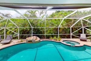 a swimming pool with chairs and a large building at Eastwood Hideaway in Fort Pierce