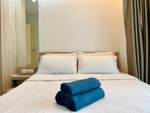 a bed with two blue towels laying on it at LPN Cha-am Beachfront Wifi 10 meters to beach 1BR ติดทะเล in Cha Am