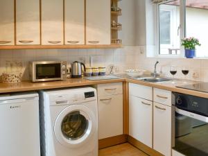 a kitchen with a washing machine and a sink at Clip Clops in Findon