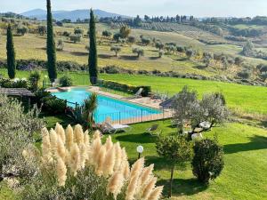 an external view of a villa with a swimming pool in a field at Agriturismo San Tommaso in Pomarance