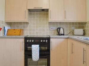 a kitchen with a stove with a towel on the oven at Stable Cottage 4 - Ukc3743 in Bawdeswell