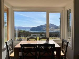 a dining room with a table and a large window at Greenhill in Portree