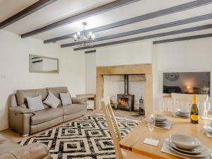 a living room with a couch and a table and a fireplace at Kerseycleugh Bridge Cottage in Kielder
