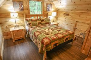 ein Schlafzimmer mit einem Bett in einer Blockhütte in der Unterkunft Gorgeous 32in GatlinburgwFree Tickets to Dollywood,Anakeesta,AquariumClose2RockyTopSportsWorld in Gatlinburg