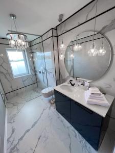 a white bathroom with a sink and a mirror at NOVAPART AKAASIA in Cluj-Napoca