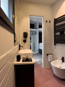ein Badezimmer mit einem Waschbecken, einem WC und einem Spiegel in der Unterkunft VICOLO SAN GAETANO -luxury rooms- in Catania