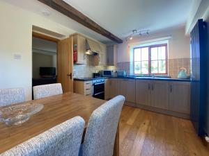 a large kitchen with a wooden table and chairs at Hazelrigg Farm in Newby Bridge