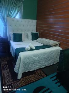 a bedroom with a large white bed with a headboard at The Croc Guest house in Springs +69 photos
