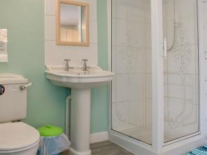 a bathroom with a sink and a toilet and a shower at Old Town Cottage in Sidmouth