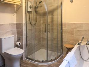 a shower stall in a bathroom with a toilet at Forge Mill Cottage in Dalbeattie