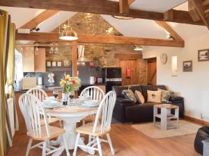 a kitchen and living room with a table and chairs at The Chapel Barn in Llangynllo
