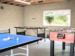 2 mesas de ping pong en una sala de ping pong en The Grooms Cottage, en Mauchline