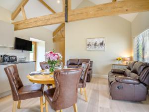 a living room with a wooden table and leather chairs at The Ash - Arnolds Hill in Wingfield