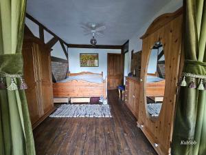 1 dormitorio con 2 camas y paredes de madera en Earthship Mierzeszyn en Mierzeszyn