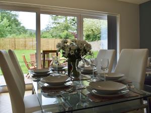a dining room table with a vase of flowers on it at Briar Cottage in Gargunnock