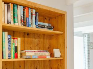 a wooden book shelf with books on it at Bon Accorde in Goodwick