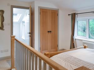 a bedroom with a bed and a wooden door at The Nest in Uny Lelant