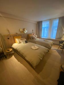 a bedroom with two beds and a girl sitting on the bed at Maison de ville - 4 personnes - Ô coeur de Spa in Spa