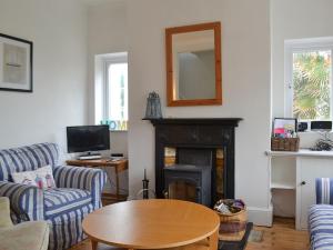 a living room with a table and a fireplace at Beech Cottage in Whitwell