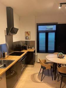 a kitchen with a table and a table and chairs at Maison de ville - 4 personnes - Ô coeur de Spa in Spa